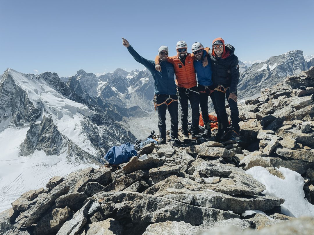 Vier Bergsteiger stehen auf dem Gipfel des Mount Jenga